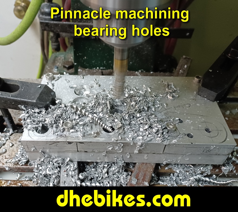Pinnacle Innovations picture showing machining in progress of the bearing holes for two Norco custom downhill bike's long travel rear suspension linkage plates made from 6061 aircraft aluminum.
